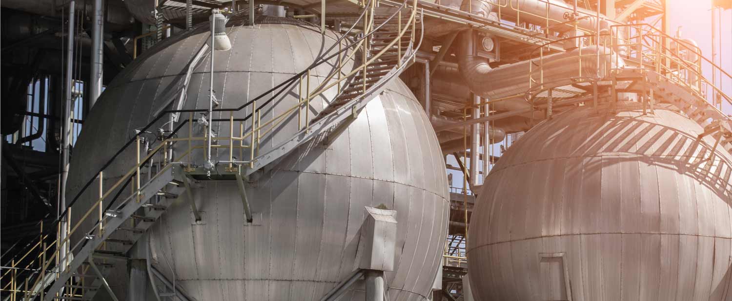 a1-oilrefinery-plant_0.jpg Large spherical industrial storage tanks connected by metal pipes and staircases, lit by sunlight, underscore the infrastructure projects supported by Africa Investment initiatives.
