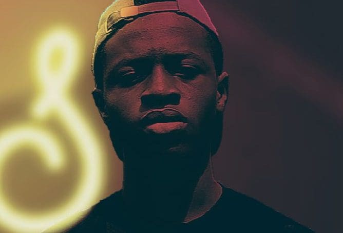 Johnel-NG-e1667329283578.jpg A person wearing a cap looks directly at the camera with a serious expression, illuminated by a glowing symbol in the background. The captivating scene speaks volumes to Johnel NG's followers.