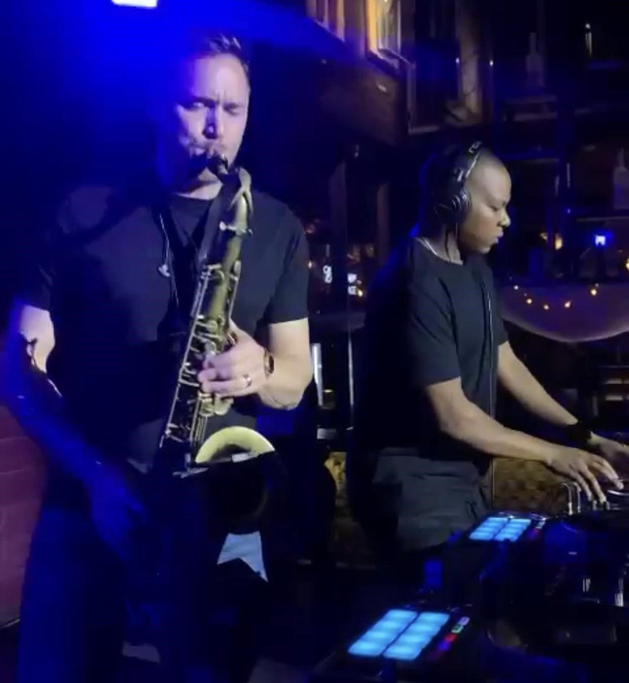 rock-cafe.jpg Two musicians perform on stage at the Rock Cafe in Lagos; one plays the saxophone while the other operates a DJ controller, creating an unforgettable atmosphere.
