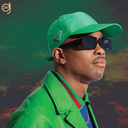 artwork-440x440-1.jpg A person wearing a green hat, green jacket, and dark sunglasses looks to the side against a sky background, embodying the essence of DJ Stokie's album "My Journey Continues.