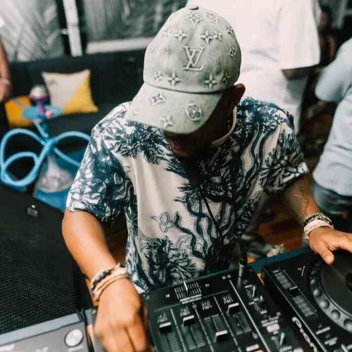 A man wearing a hat from the Kabza De Small – Kitchen Unit Mixtape S4 E1 is djing at a party. A man wearing a hat from the Kabza De Small – Kitchen Unit Mixtape S4 E1 is djing at a party.