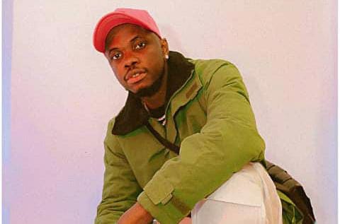A man in a green jacket with a pink hat reemerges in the music scene. A man in a green jacket with a pink hat reemerges in the music scene.