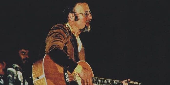 A man playing an acoustic guitar. A man playing an acoustic guitar.