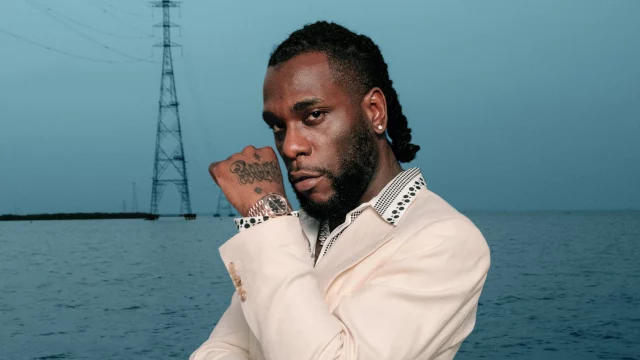 A man with dreadlocks standing next to water. A man with dreadlocks standing next to water.