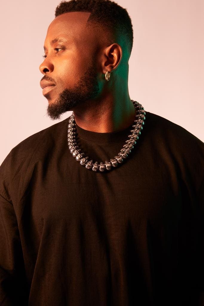 A man in a black shirt with a necklace, representing Music Saved My Life - Chygoz. A man in a black shirt with a necklace, representing Music Saved My Life - Chygoz.