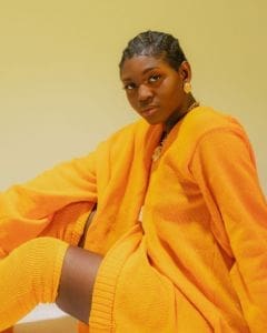 A woman in an orange sweater seeking support for women. A woman in an orange sweater seeking support for women.