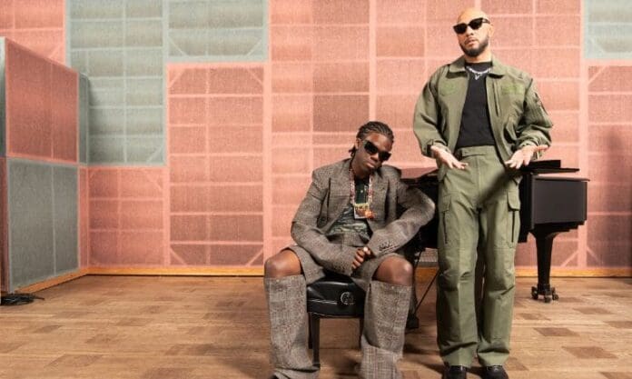 Two men, Rema and Swizz Beatz, standing next to each other in a recording studio with a purpose.