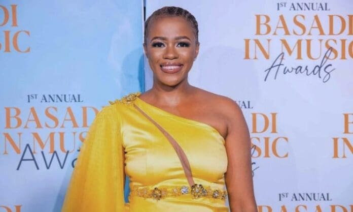 A Basadi woman in a yellow dress standing on the red carpet at the Music Awards. A Basadi woman in a yellow dress standing on the red carpet at the Music Awards.