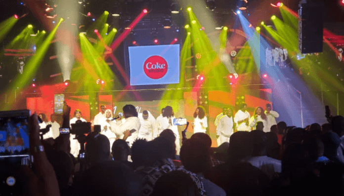 A Coke Studio Amplified spectacle with a symphony of sound, featuring a group of people on stage at a concert. A Coke Studio Amplified spectacle with a symphony of sound, featuring a group of people on stage at a concert.