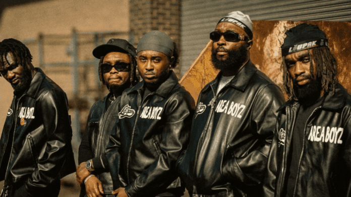 Wiziboy_20250503_130907_0000.png Five men stand side by side outdoors in black leather jackets with "NICA BOYZ" written on them, channeling the confident energy of The Compozers or NSG at a Tesco Live Performance as they look seriously towards the camera.