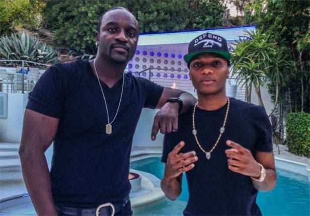 akon-and-Wizkid.jpg Two men pose together outdoors by a pool, both wearing black t-shirts and jewelry. The man on the right, channeling Afrobeats style, makes a hand gesture while wearing a black cap.