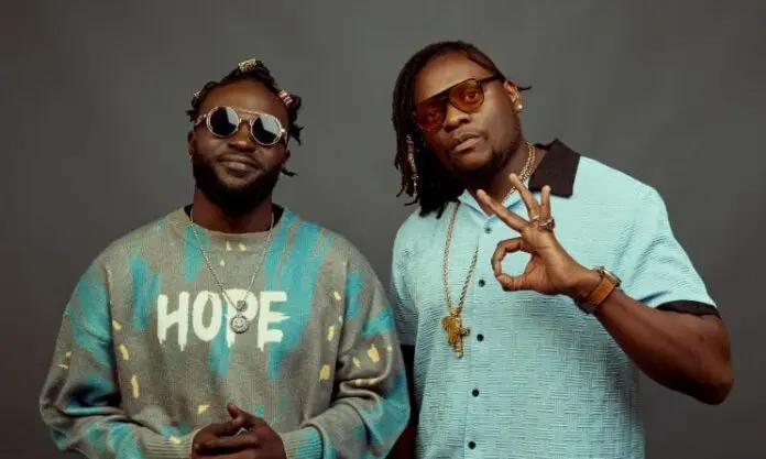 calvonaiboi31.jpg Two men, Zama and Naiboi, stand in front of a gray background. One wears a "HOPE" sweater; both sport sunglasses and gold chains, with one making an "OK" hand gesture.