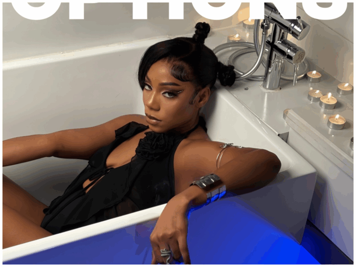 f7377ca4-fb1d-40ba-9f86-9ab3878c355b.png A woman in a black outfit sits in a white bathtub, surrounded by lit tealight candles, with her arm resting on the tub’s edge—a scene reminiscent of music videos by artists like Tesh Carter featured on Pulse Nigeria.