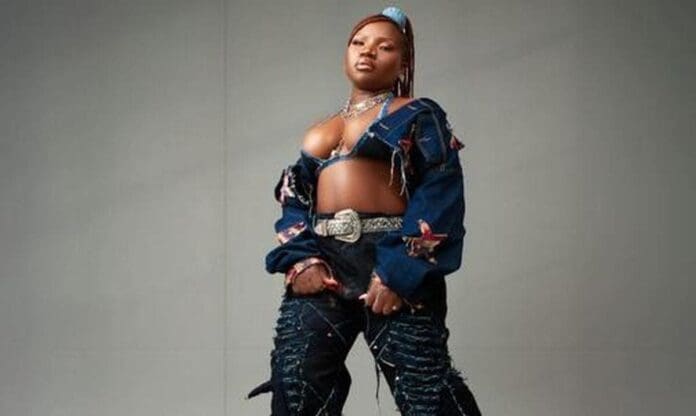 tpg2Fsources2Ffd64cbda-ef0d-49f3-8264-15c22e781765.jpeg A person stands against a plain background wearing a cropped denim jacket, a bralette, decorated pants, statement jewelry, and a large belt buckle—ready for the METRO FM Music Awards 2025.